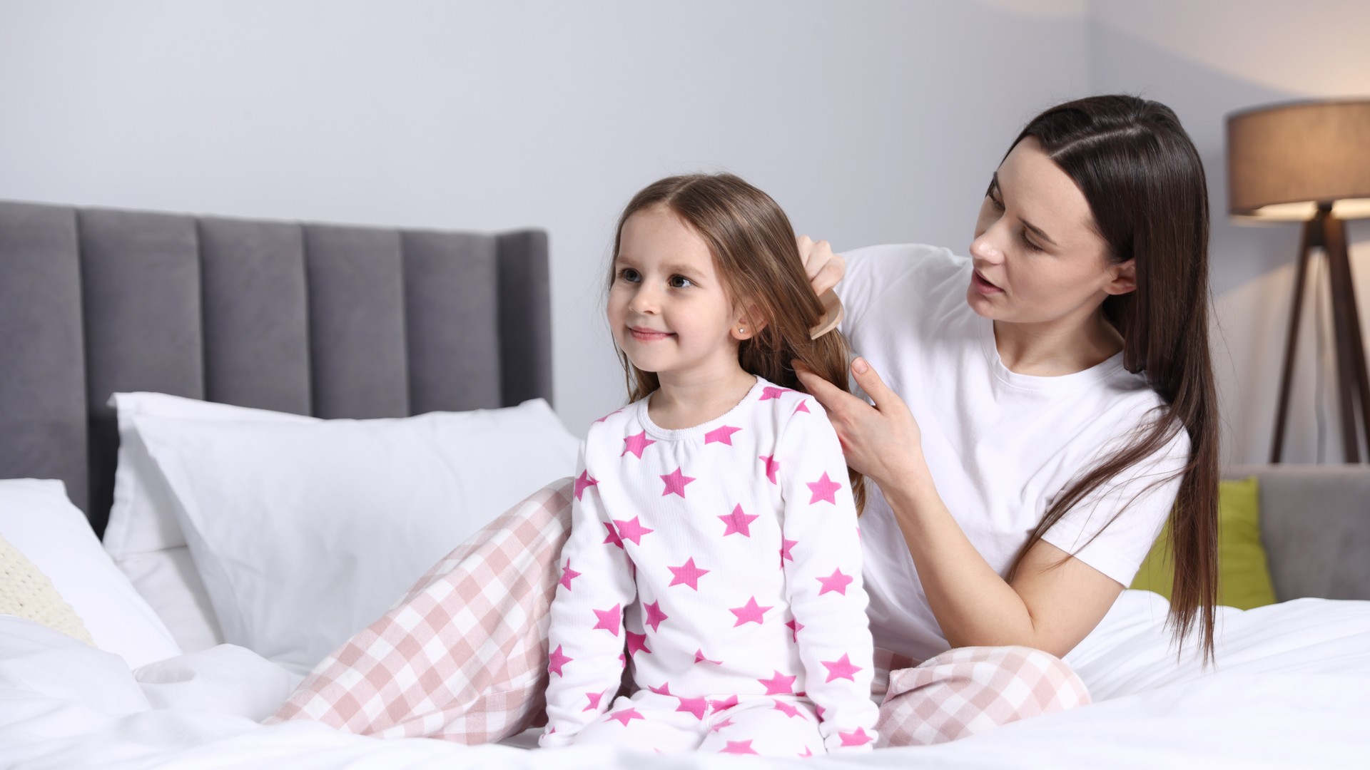 Parent calmly checking a child for lice at home