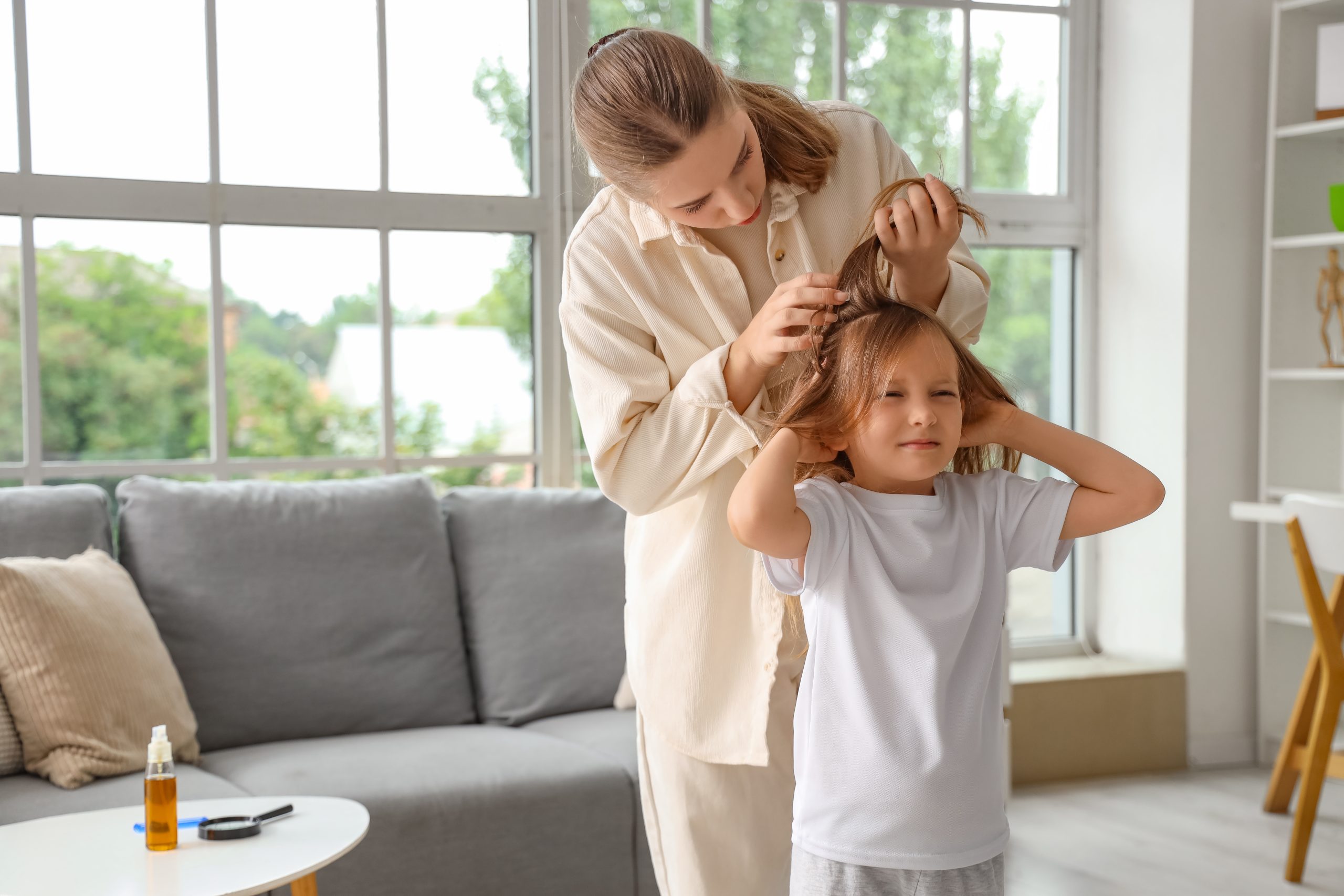Parent screening a child's scalp for head lice at home