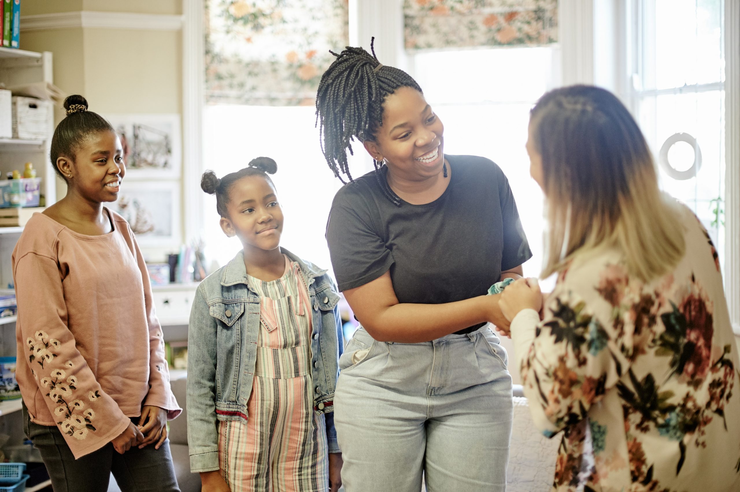 Parent and teacher meeting in a classroom with children nearby