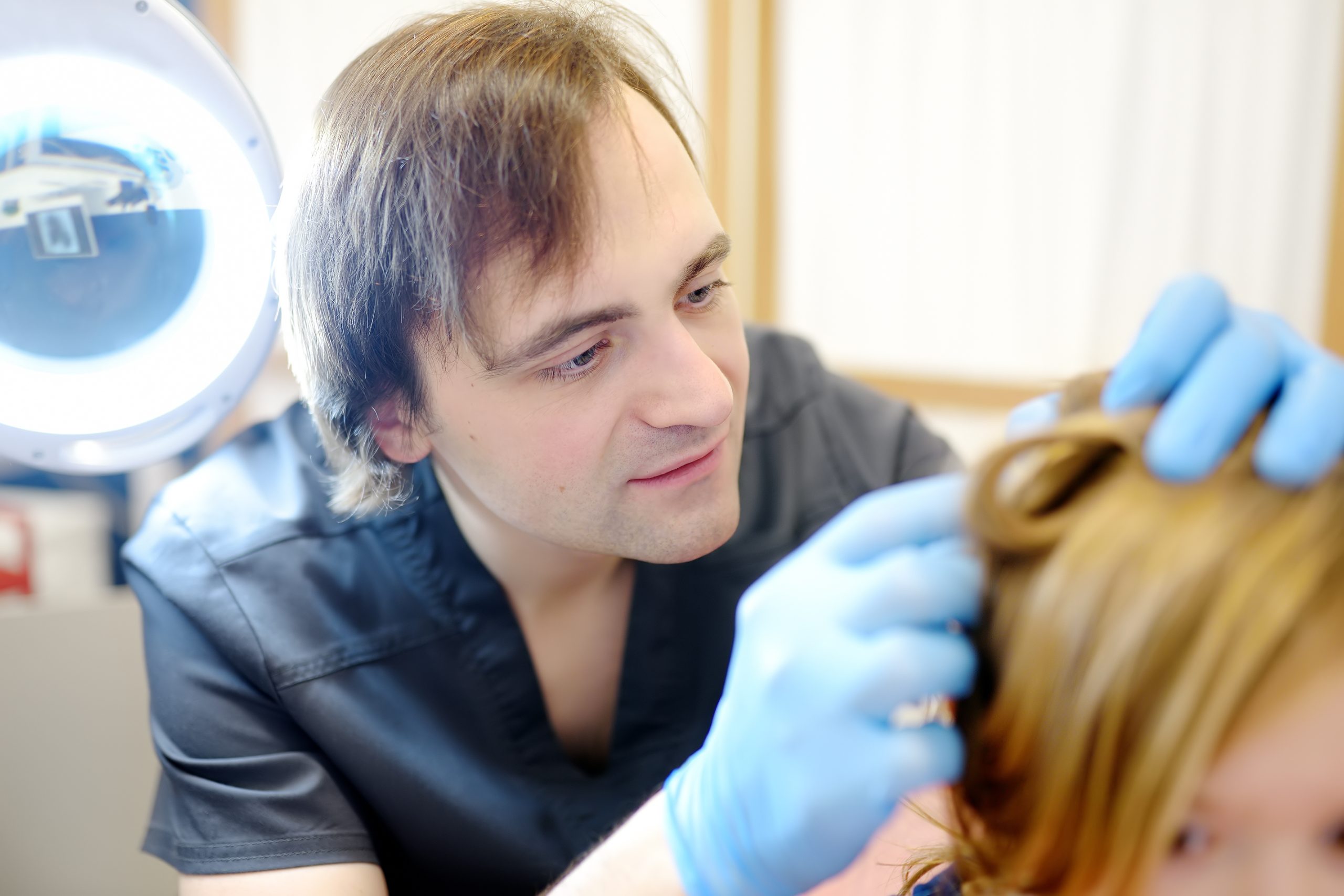 A clinician checks a young child's hair and scalp for lice at a Union County screening